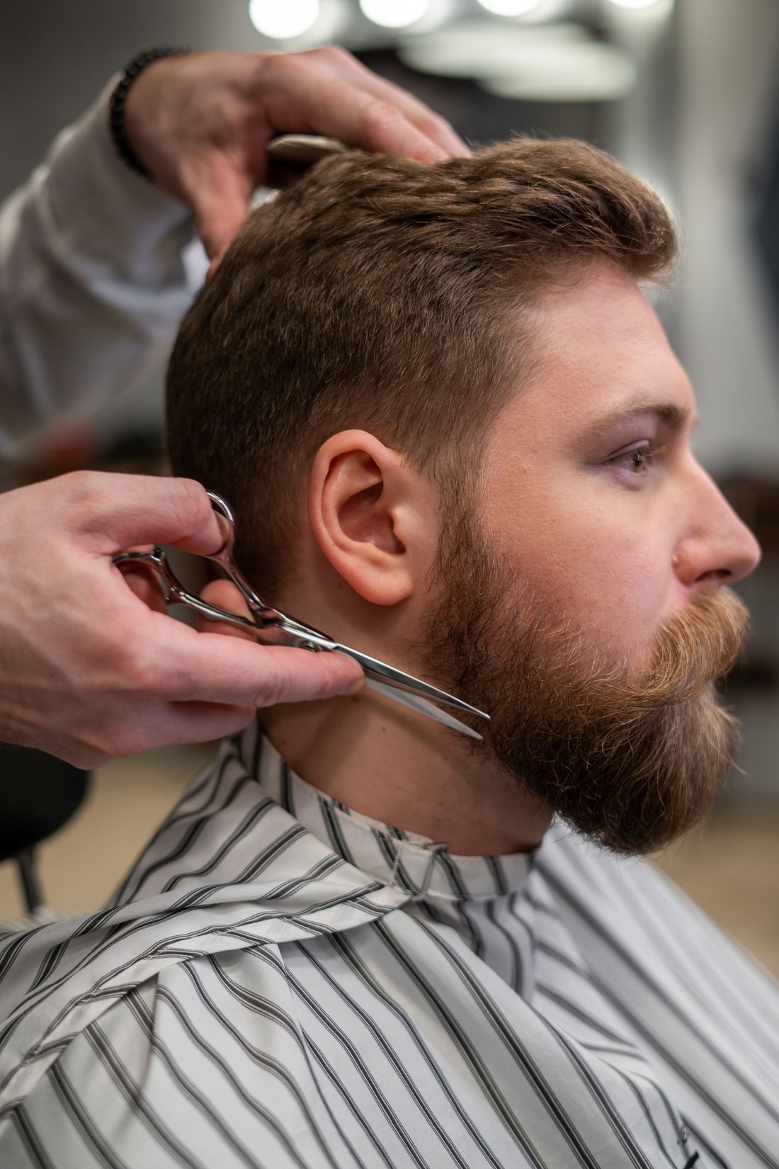 Barbier taillant la barbe d’un client aux ciseaux
