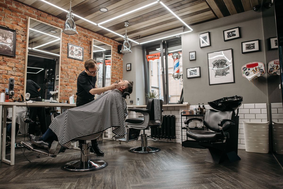 Barbier au travail dans un salon lumineux aux murs de briques