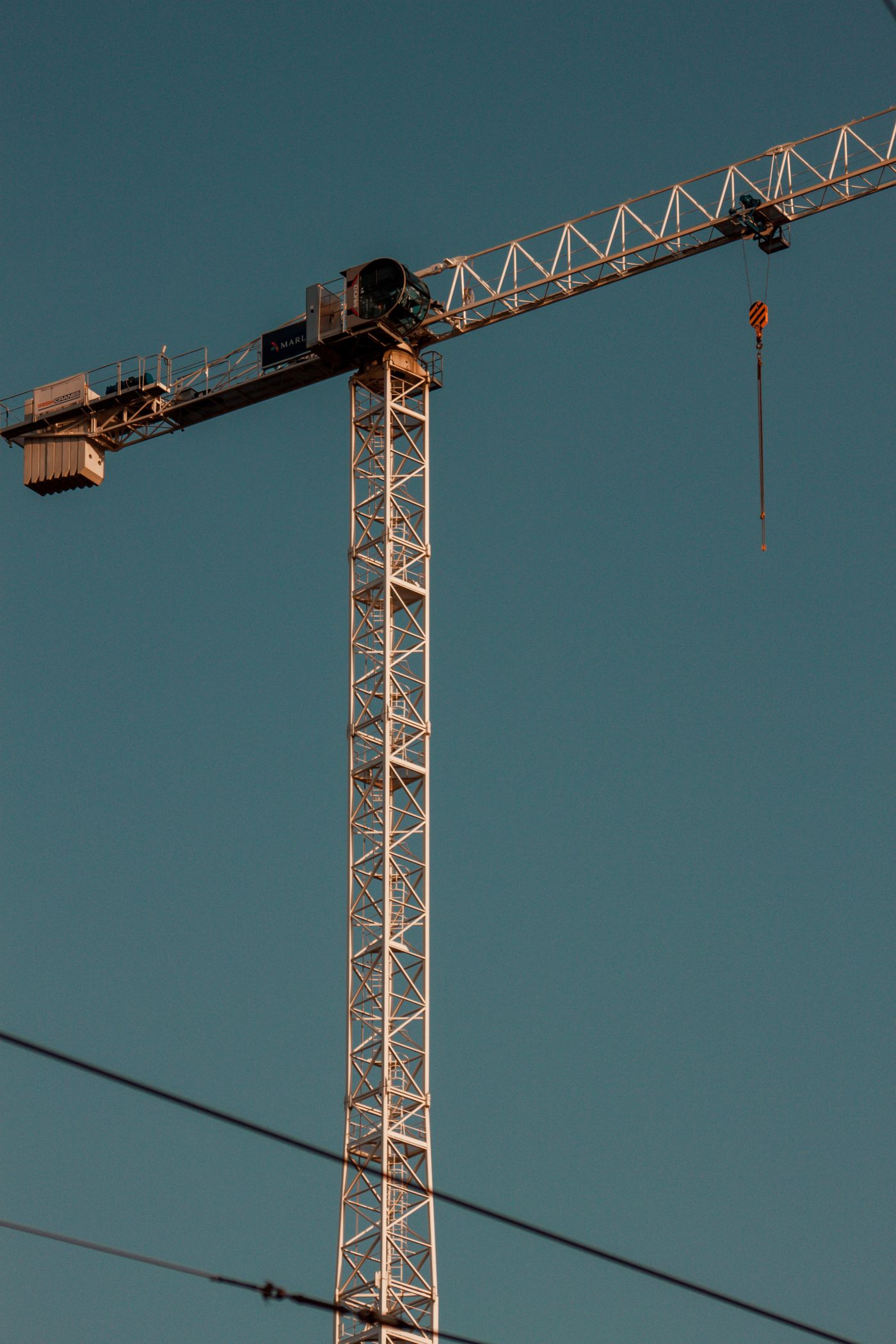 Grue à tour jaune se détachant sur un ciel bleu-vert