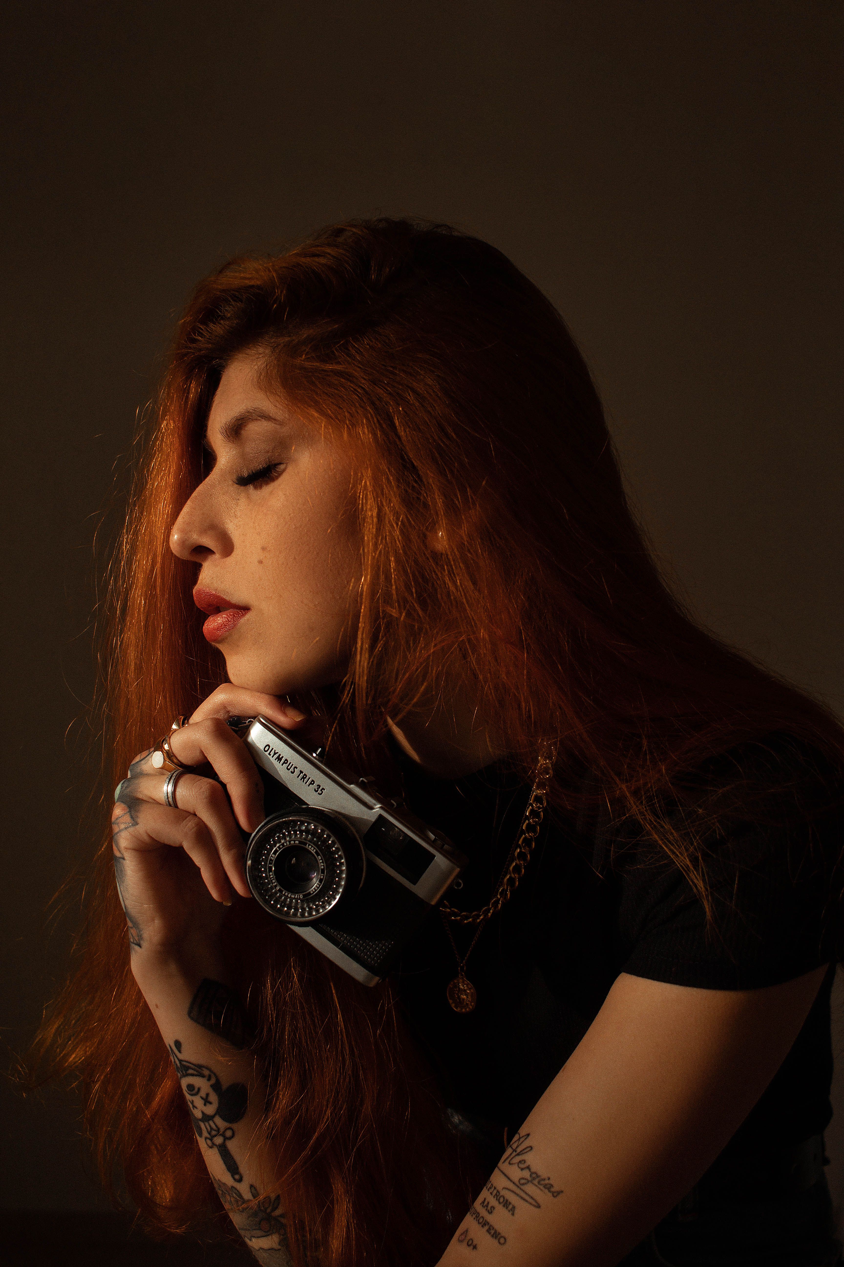 Une photographe indépendante tient son appareil dans une lumière chaude et cinématographique